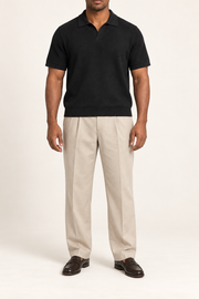 Still Hour Knit Polo in Black. Front view showing the plain knit and open polo neckline.