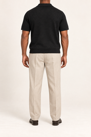 Still Hour Knit Polo in Black. Rear view showing the plain back and ribbed hem.