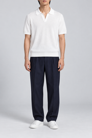 Still Hour Knit Polo in White. Front view showing the plain white knit and open polo neckline.
