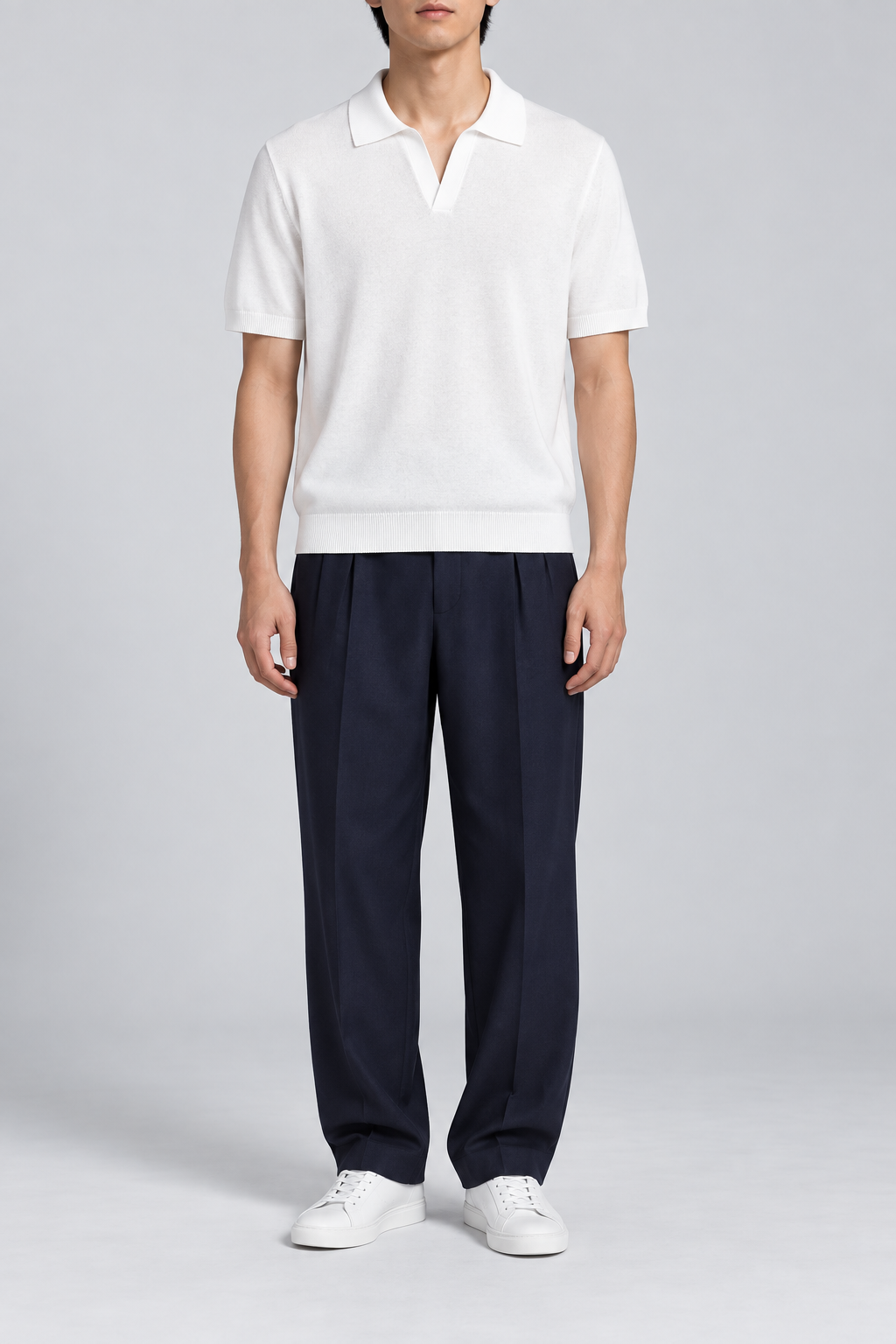 Still Hour Knit Polo in White. Front view showing the plain white knit and open polo neckline.