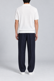 Still Hour Knit Polo in White. Rear view showing the plain back and ribbed hem.