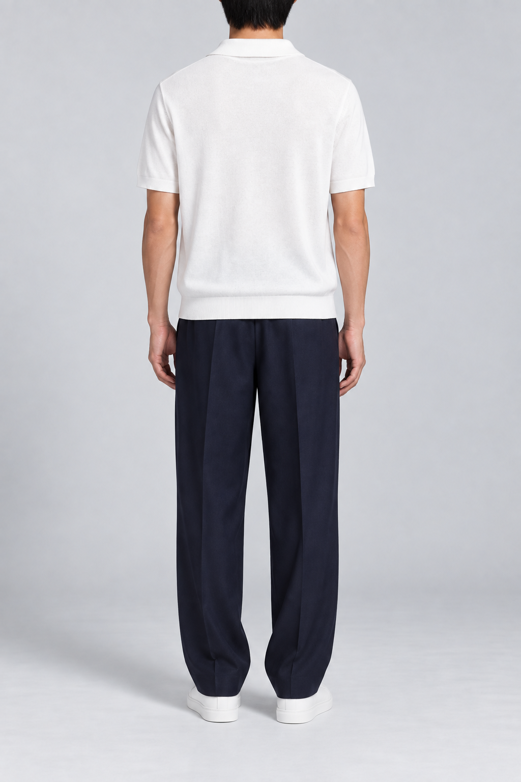 Still Hour Knit Polo in White. Rear view showing the plain back and ribbed hem.