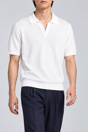 Still Hour Knit Polo in White. Walking view showing the loose silhouette and knit drape.