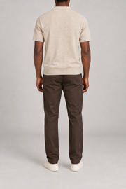 Still Hour Knit Polo in Mild Apricot. Rear view showing the plain back and ribbed hem.