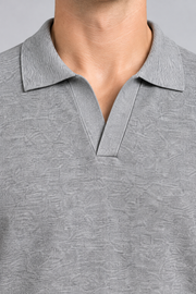 Close-up studio view showing the heather knit and ribbed collar of Still Hour Knit Polo in Flower Gray.