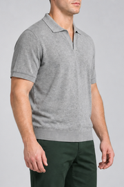 Three-quarter side studio view showing the loose fit and ribbed hem of Still Hour Knit Polo in Flower Gray.