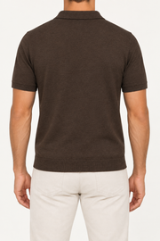 Rear studio view showing the plain back and short sleeves of Still Hour Knit Polo in Dark Brown.