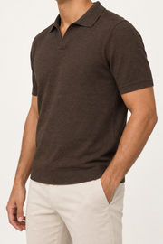 Three-quarter side studio view showing the sleeve seam and loose fit of Still Hour Knit Polo in Dark Brown.