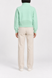Rear studio view showing the curved yoke and ribbed back hem panel of Curve Interval Half-Zip Sweatshirt in Green.