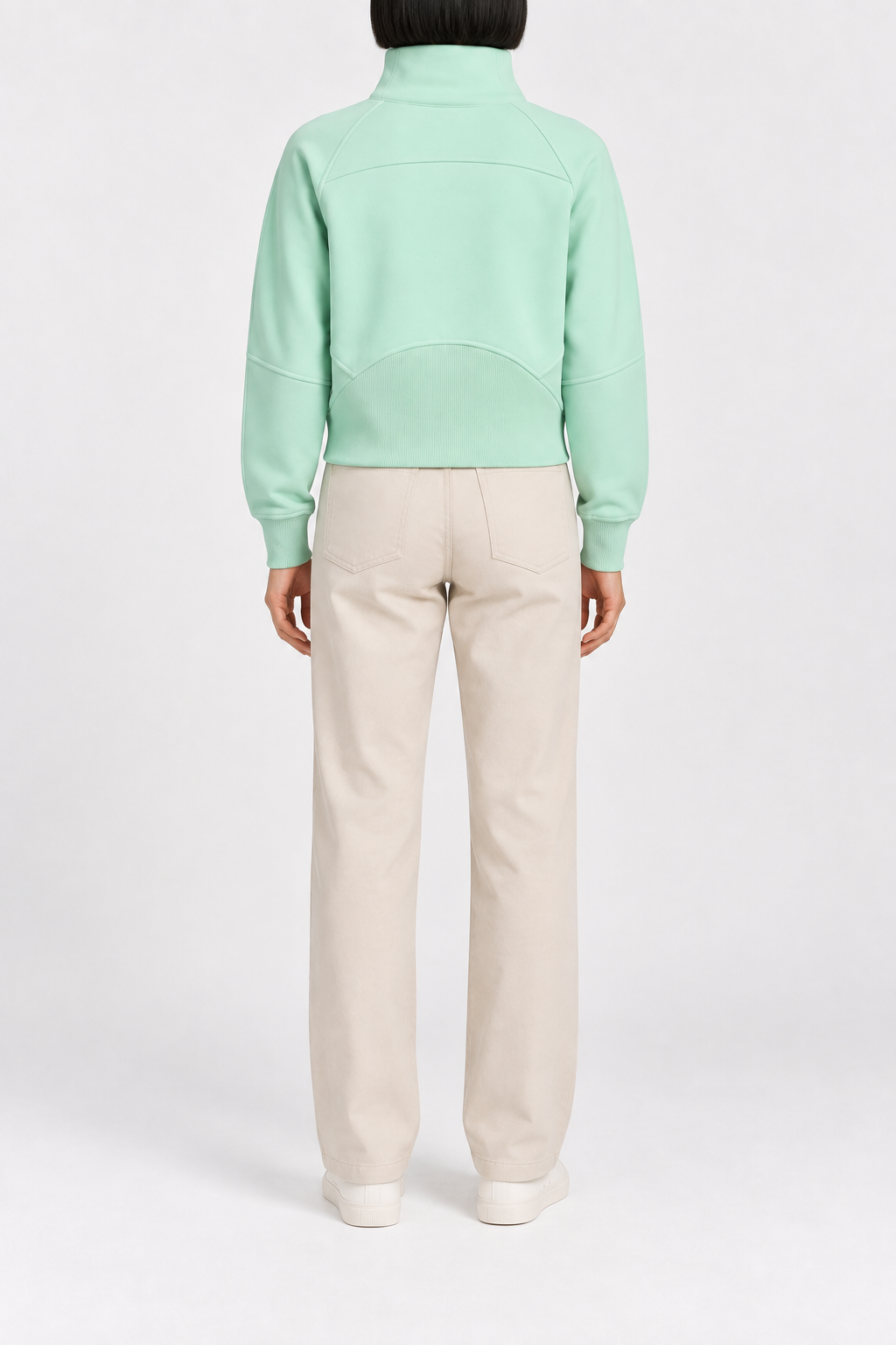 Rear studio view showing the curved yoke and ribbed back hem panel of Curve Interval Half-Zip Sweatshirt in Green.