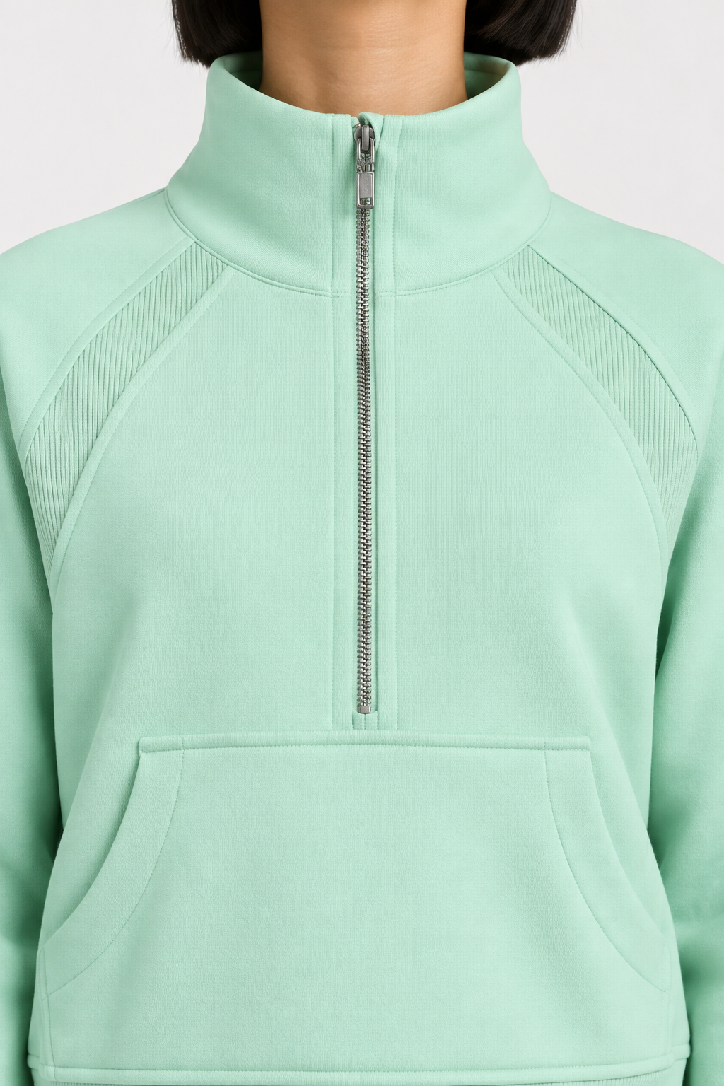 Close-up studio view showing the high collar, silver-tone zip and ribbed shoulder inserts of Curve Interval Half-Zip Sweatshirt in Green.