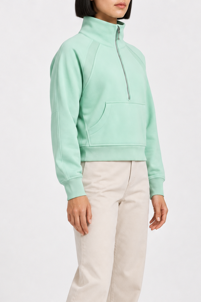 Three-quarter side studio view showing the raglan sleeves and cropped silhouette of Curve Interval Half-Zip Sweatshirt in Green.