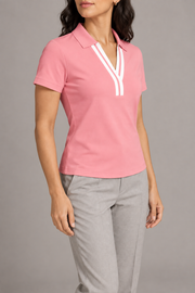 Court Ease V-Neck Polo in Pink. Three-quarter studio view showing the short sleeves and straight hem.