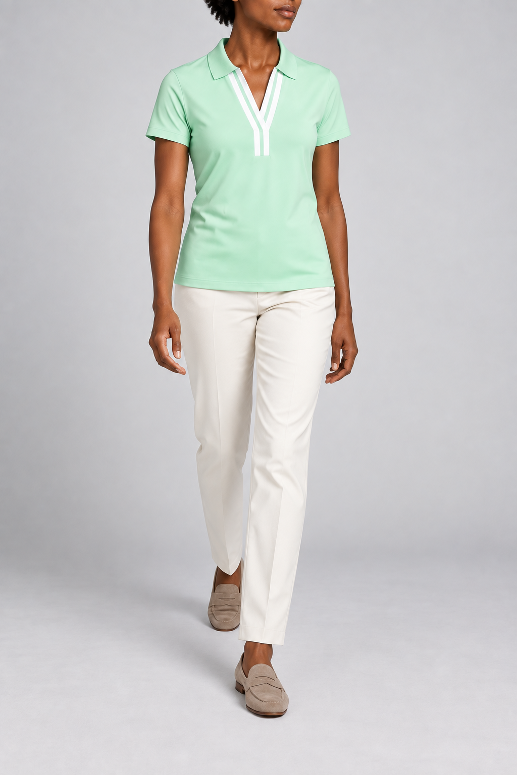 Court Ease V-Neck Polo in Mint Green. Walking studio view showing the mint green polo's natural drape.