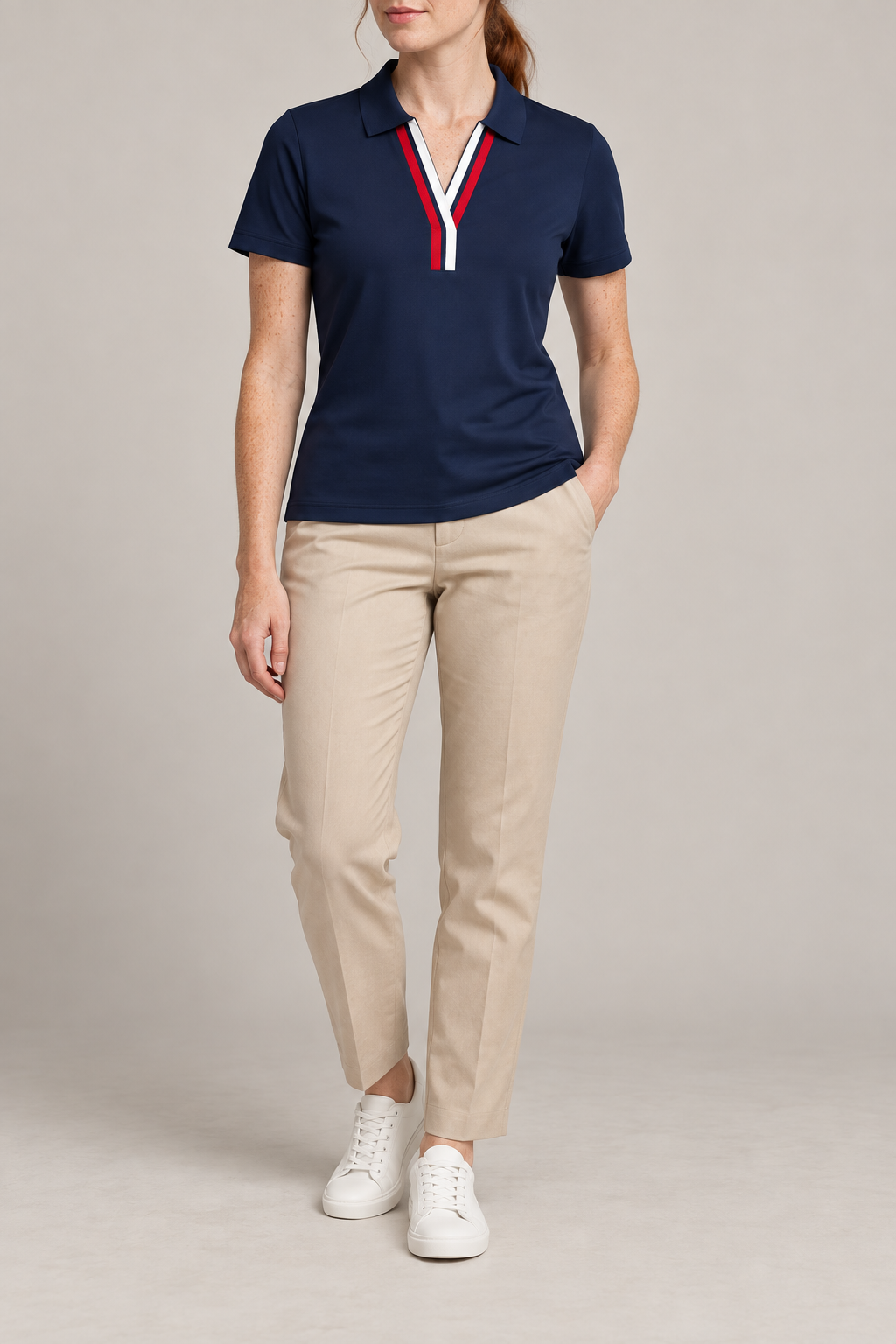 Court Ease V-Neck Polo in Navy Blue. Front studio view showing the red and white V-neck bands and slim silhouette.