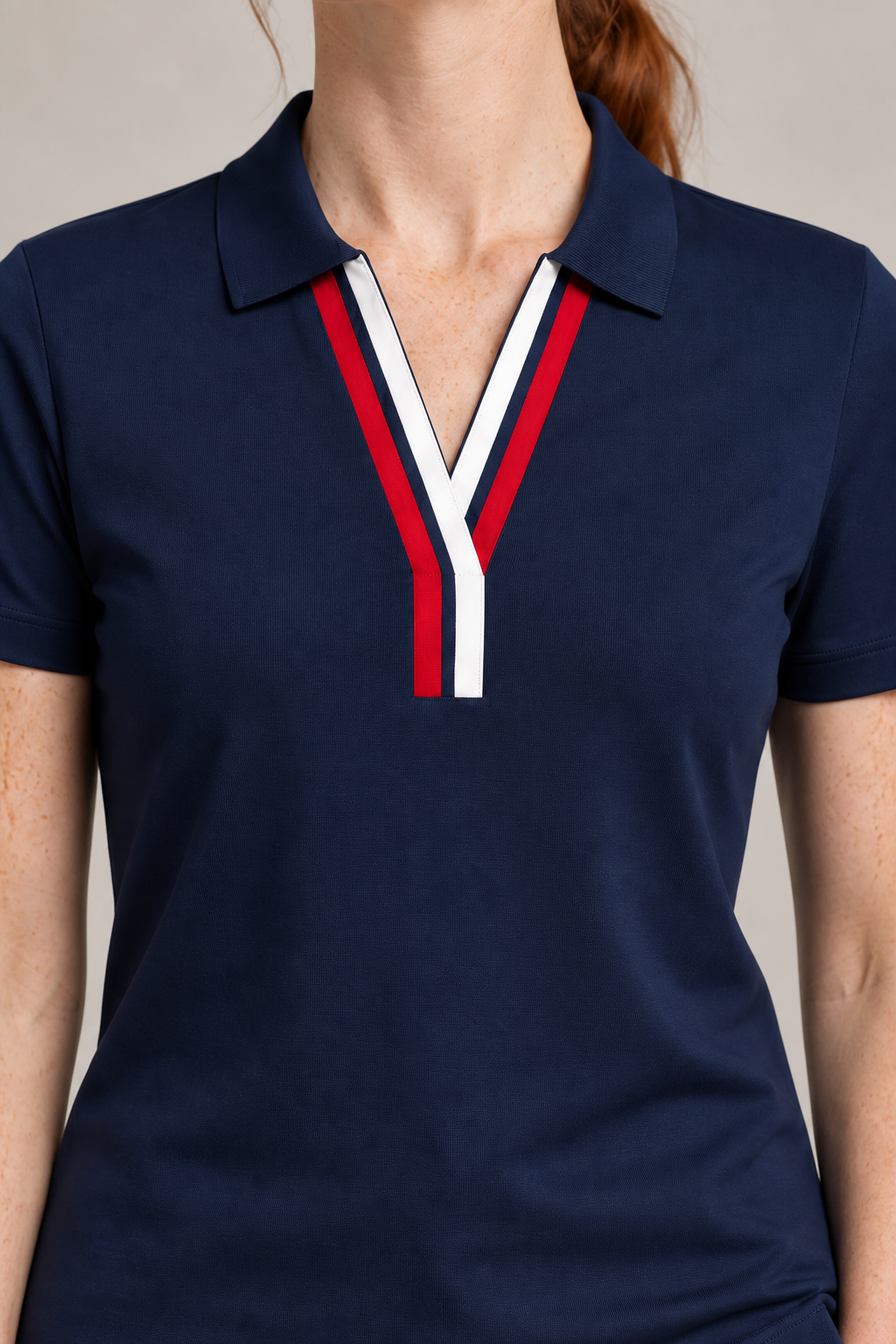 Court Ease V-Neck Polo in Navy Blue. Close-up of the navy ribbed collar with red and white neckline bands.