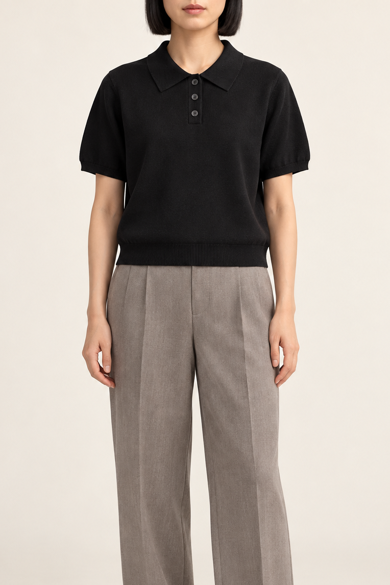 Soft Poise Knit Polo in Black. Front studio view showing the short boxy shape and three-button placket.