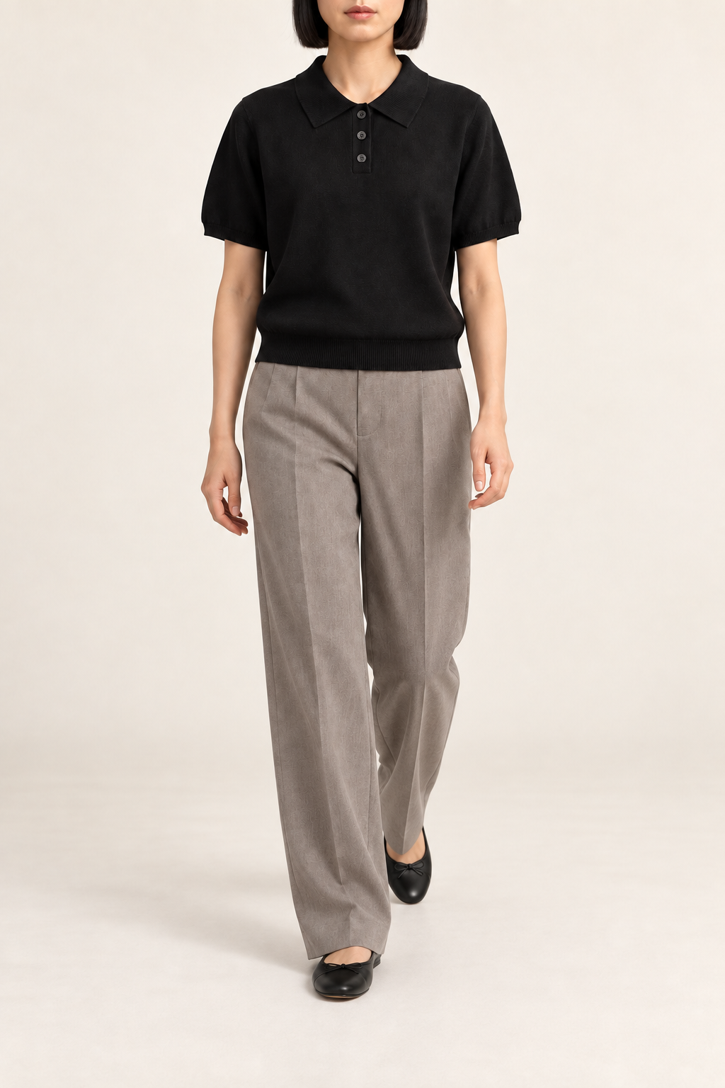 Soft Poise Knit Polo in Black. Walking studio view showing the black polo's relaxed drape.