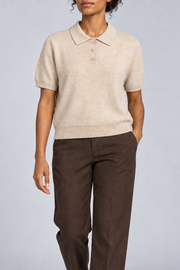 Soft Poise Knit Polo in Apricot. Front studio view showing the short boxy shape and three-button placket.