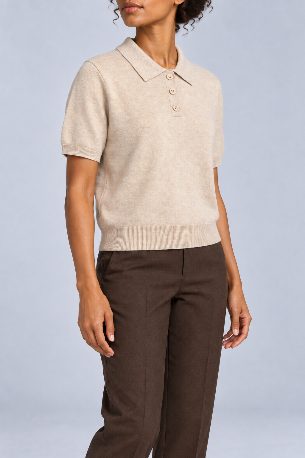 Soft Poise Knit Polo in Apricot. Three-quarter studio view showing short sleeves and ribbed cuffs and hem.