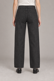 Worn Rhythm Straight Jeans in Black. Rear studio view showing two plain patch pockets and tonal stitching.