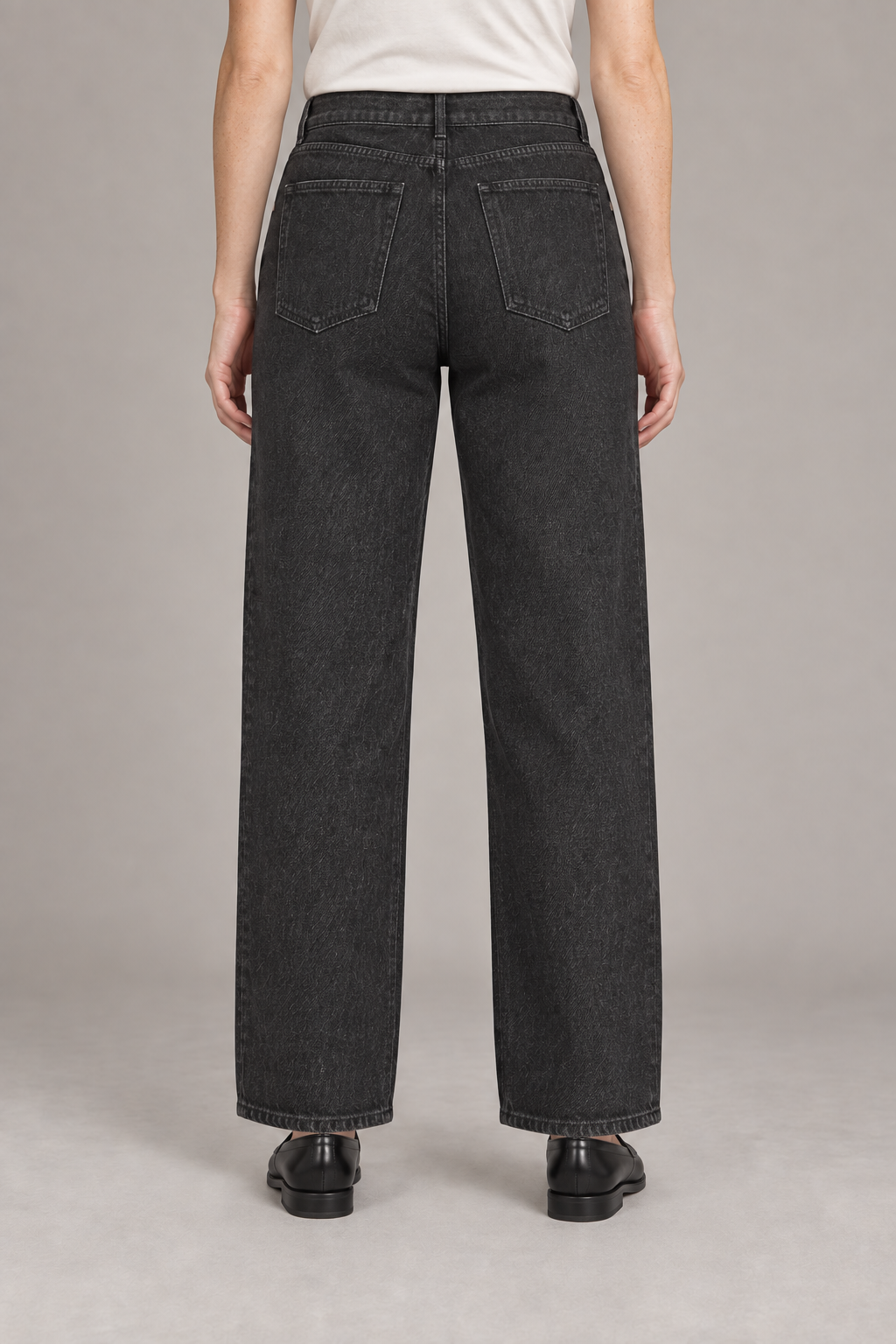 Worn Rhythm Straight Jeans in Black. Rear studio view showing two plain patch pockets and tonal stitching.