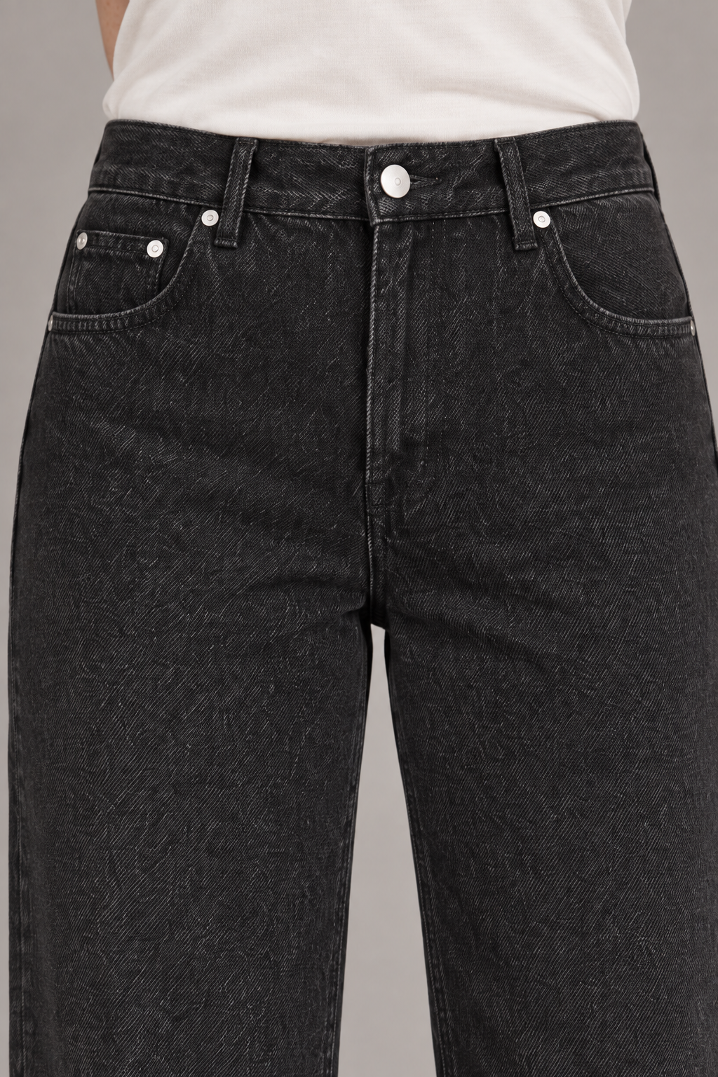 Worn Rhythm Straight Jeans in Black. Close-up showing the black denim waistband, coin pocket and silver-tone rivets.