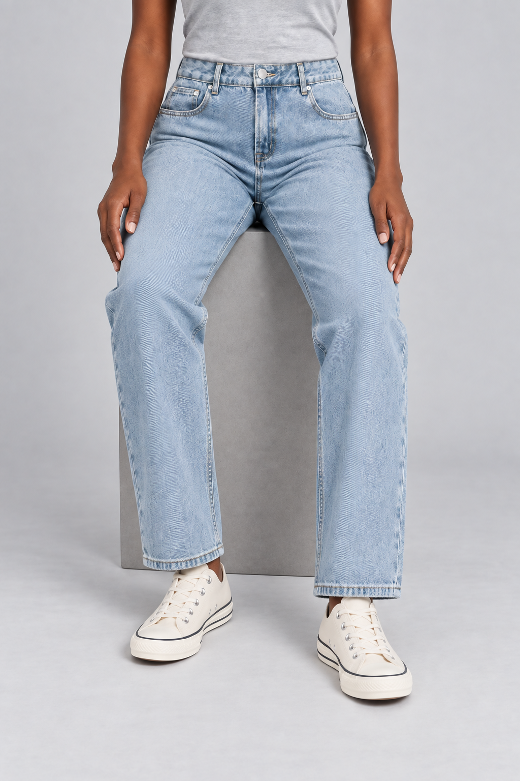 Worn Rhythm Straight Jeans in Blue. Seated studio view showing the blue jeans' straight-leg drape.