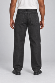 Rear studio view of Still Rhythm Straight Jeans in Black, showing plain patch pockets and the back yoke.