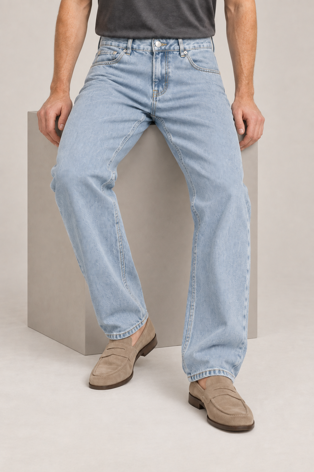 Seated studio view of Still Rhythm Straight Jeans in Blue, showing the loose denim drape.