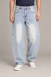 Front studio view of Pale Orbit Barrel Jeans in Light Blue, showing sunfaded thighs and curved leg seams.
