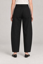 Rear studio view of Soft Arc Belted Chinos in Black, showing two plain patch pockets and a loose silhouette.