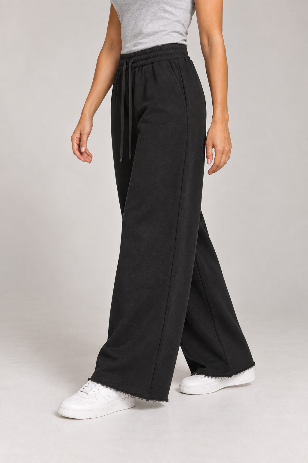 Side studio view of Soft Pause Wide Leg Sweatpants in Black, showing the side pocket and raw-edge finish.