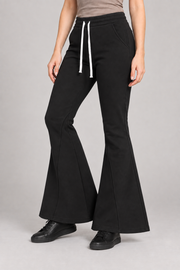 Three-quarter view of Quiet Bell Flared Sweatpants in Black, showing slash pockets and the shaped lower legs.
