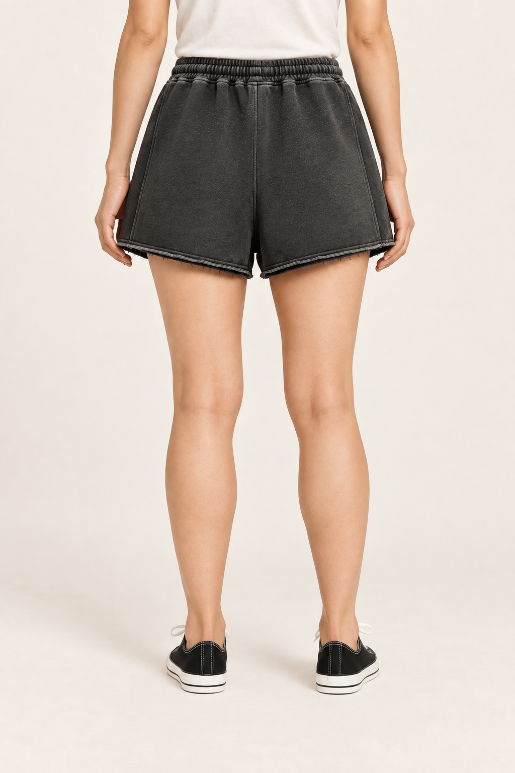 Rear studio view of Faded Hours Raw Edge Shorts in Black, showing the plain back, relaxed shape and raw hems.