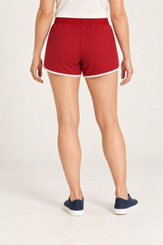 Rear studio view of Track Echo Contrast Shorts in Red, showing the curved panel seam and white hem trim.