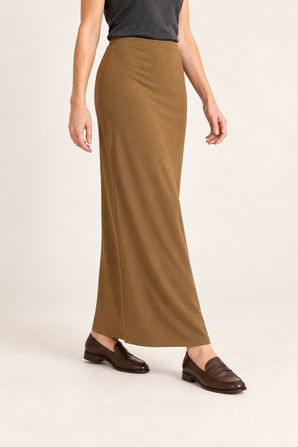 Three-quarter studio view of Quiet Column Knit Maxi Skirt in Brown, showing the long hem and fluid fabric during a natural step.