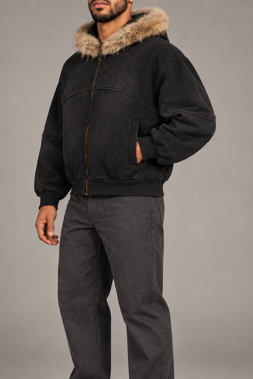 Three-quarter view of Dusk Shelter Boxy Zip Hoodie in Black showing its oversized sleeves, front pocket and washed finish.