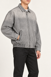 Three-quarter view of Silver Hour Zip Denim Jacket in Light Gray showing its relaxed shape and topstitched seams.