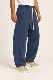 Three-quarter view of Blue Hour Mineral Wash Barrel Pants in Navy, showing side pockets, knee shaping and open hems.