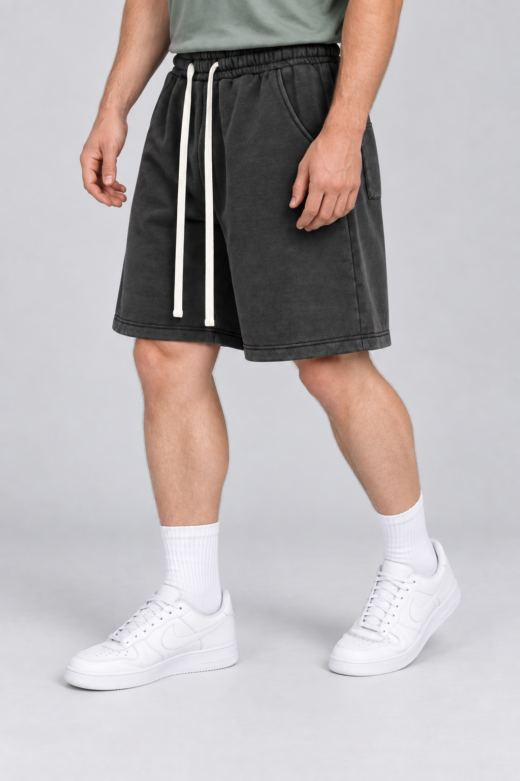 Three-quarter view of Off Duty Vintage Fleece Shorts in Black, showing slash pockets and the relaxed knee-length shape.