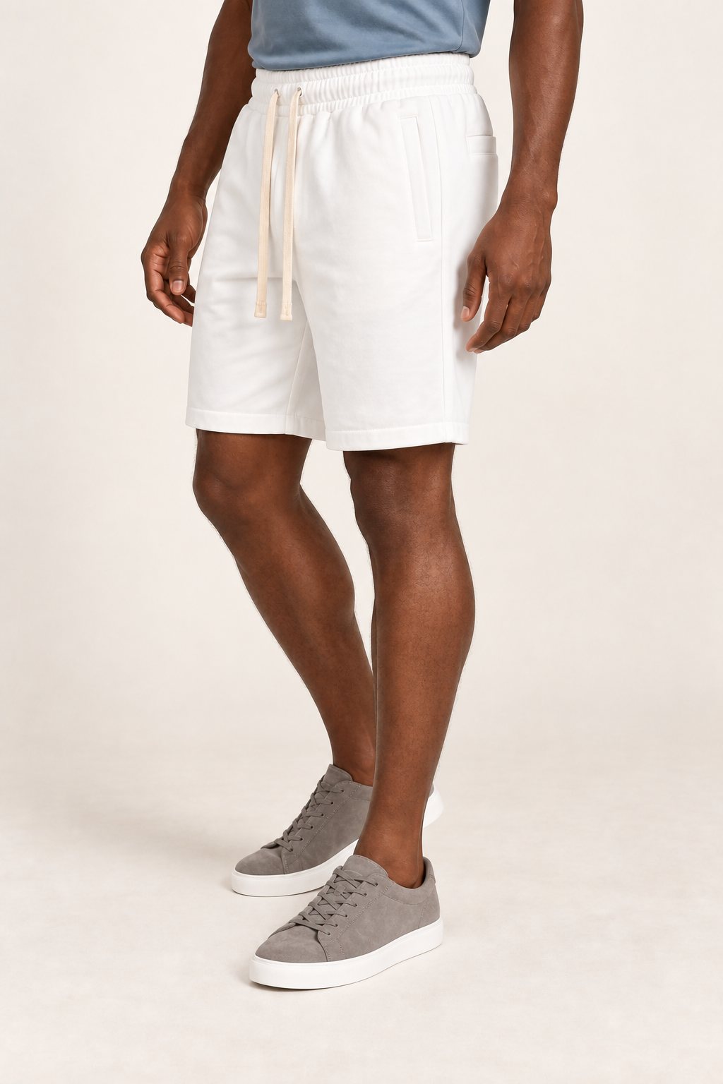 Three-quarter view of Clear Day Cotton Shorts in White, showing the loose shape, elastic waist and stitched hems.