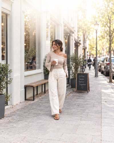 Woman in a beige top and cream trousers
