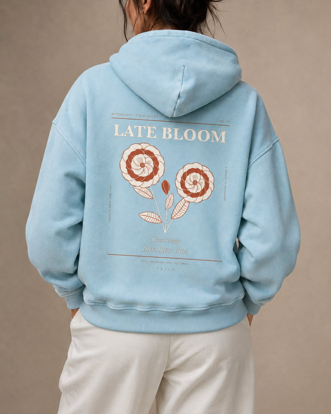 Rear studio view of the TELLS Late Bloom Poster Hoodie in Lake Blue with the full botanical back artwork.