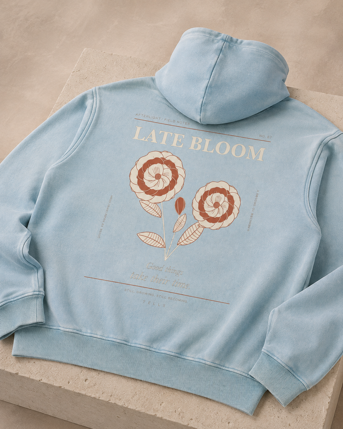Studio detail of the Late Bloom floral artwork printed across the back of the Lake Blue TELLS hoodie.