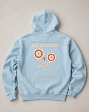 Flat lay studio view of the TELLS Late Bloom Poster Hoodie in Lake Blue showing the complete back artwork.