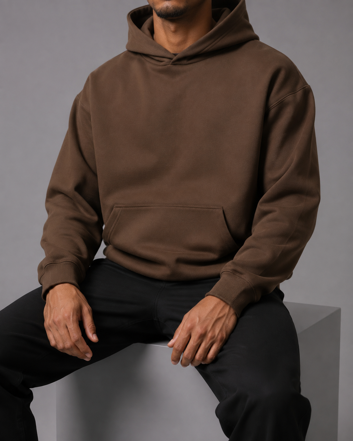 TELLS Still Coffee Hoodie, seated studio view