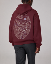 TELLS Dusk Atlas Hoodie in Dull Red, three-quarter back studio view