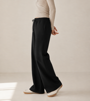 Women’s TELLS Essential Wide-Leg Black Sweatpants — cropped below face